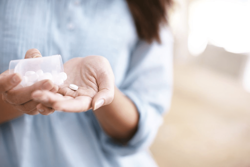 Picture of woman taking medication to manage IBS.