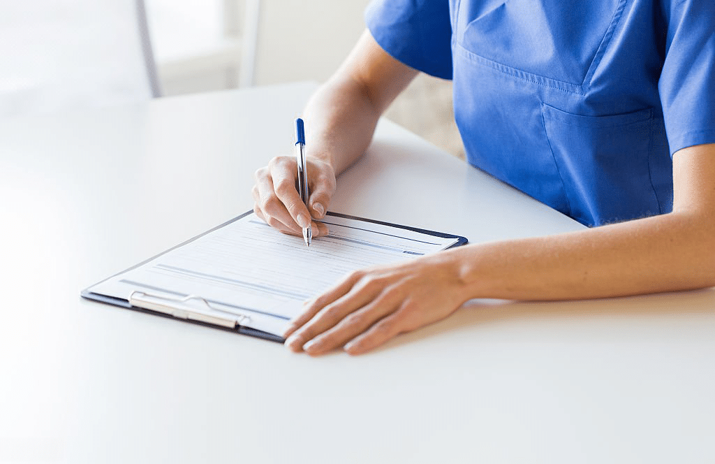 Picture of doctor diagnosing, writing on table. First Gastro Appointment. Gastroenterology services in West Ryde.